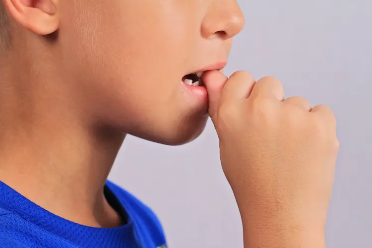 少年が爪を噛んでいる様子の写真