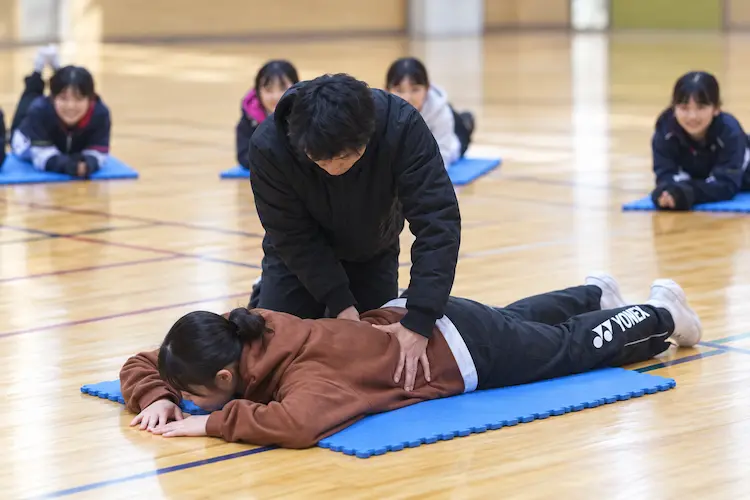 体育館での丁寧なストレッチ指導